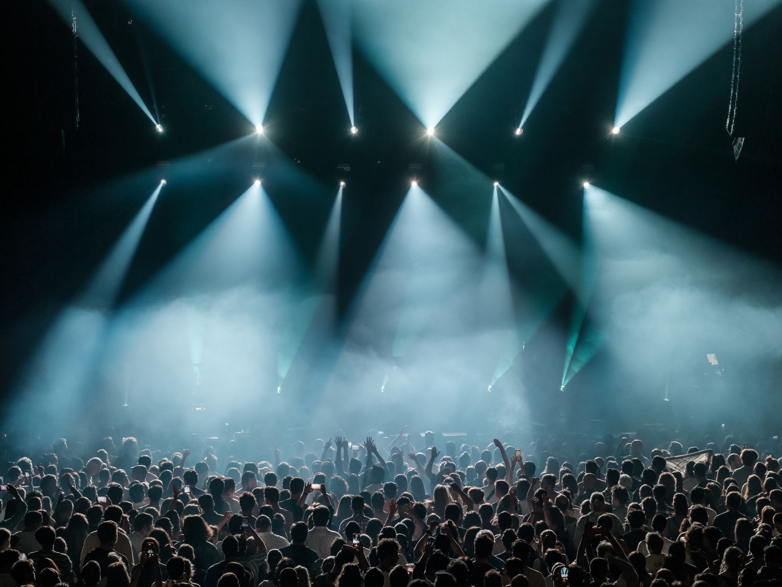 Stor publik framför en upplyst scen på en musikfestival