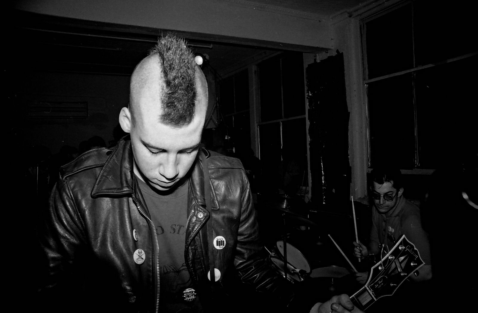 Punkband spelar live på en klubbscen i svartvitt