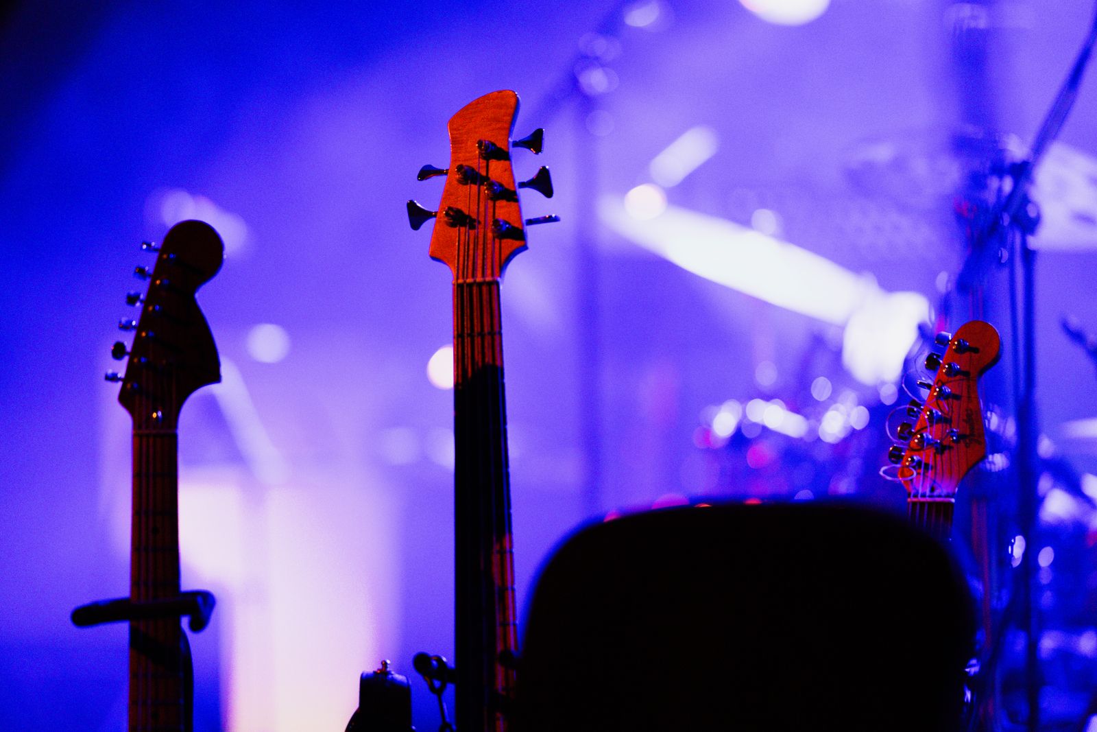 Elgitarrer uppställda på en konsertscen i färgstarkt scenljus
