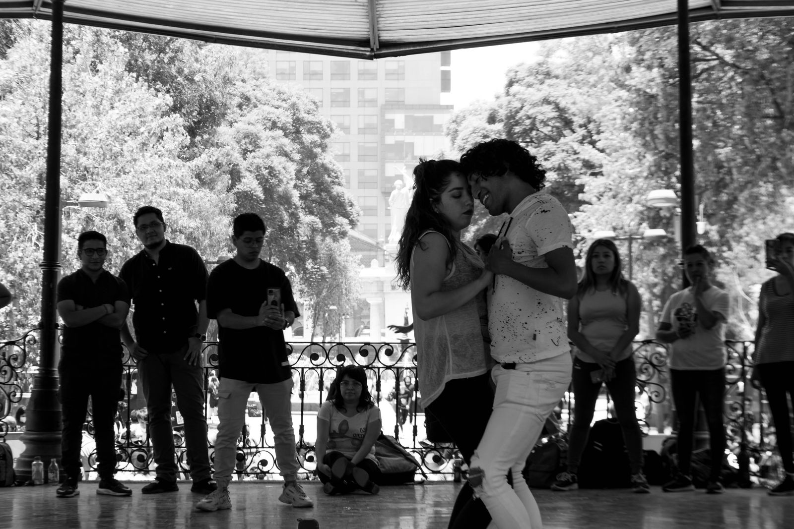 Ett par dansar på en dansbana i en park medan publiken står runt omkring