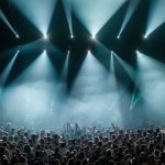 Stor publik framför en upplyst scen på en musikfestival