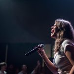 Kvinnlig artist som sjunger på en scen under ett livekonsert