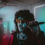 Personer som sjunger karaoke i mikrofon på en fest med neonljus
