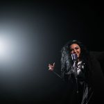 Sångerska framför passionerat en låt i strålkastarljus på scen, en symbol för svenska Eurovision-triumfer