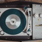 Retro skivspelare i resväskemodell som spelar en vinylskiva, en symbol för 60-talets musik