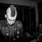 Punkband spelar live på en klubbscen i svartvitt