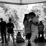 Ett par dansar på en dansbana i en park medan publiken står runt omkring